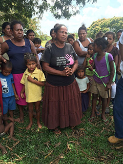 Con su comunidad, una madre habla de como un colono disparo su hija - en la camiseta amarilla - en la cabeza. Foto: Courtney Parker, Intercontinental Cry, 2016