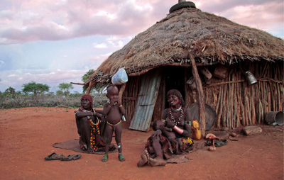 Une famille hamar devant sa maison, vallée de l'Omo, Ethiopie. Le barrage Gibe III en construction détruira les moyens de subsistance de leur people (Image: Magda Rakita/Survival)