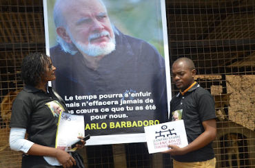 Deux bénévoles du refuge devant l'affiche à la mémoire de Giancarlo Barbadoro